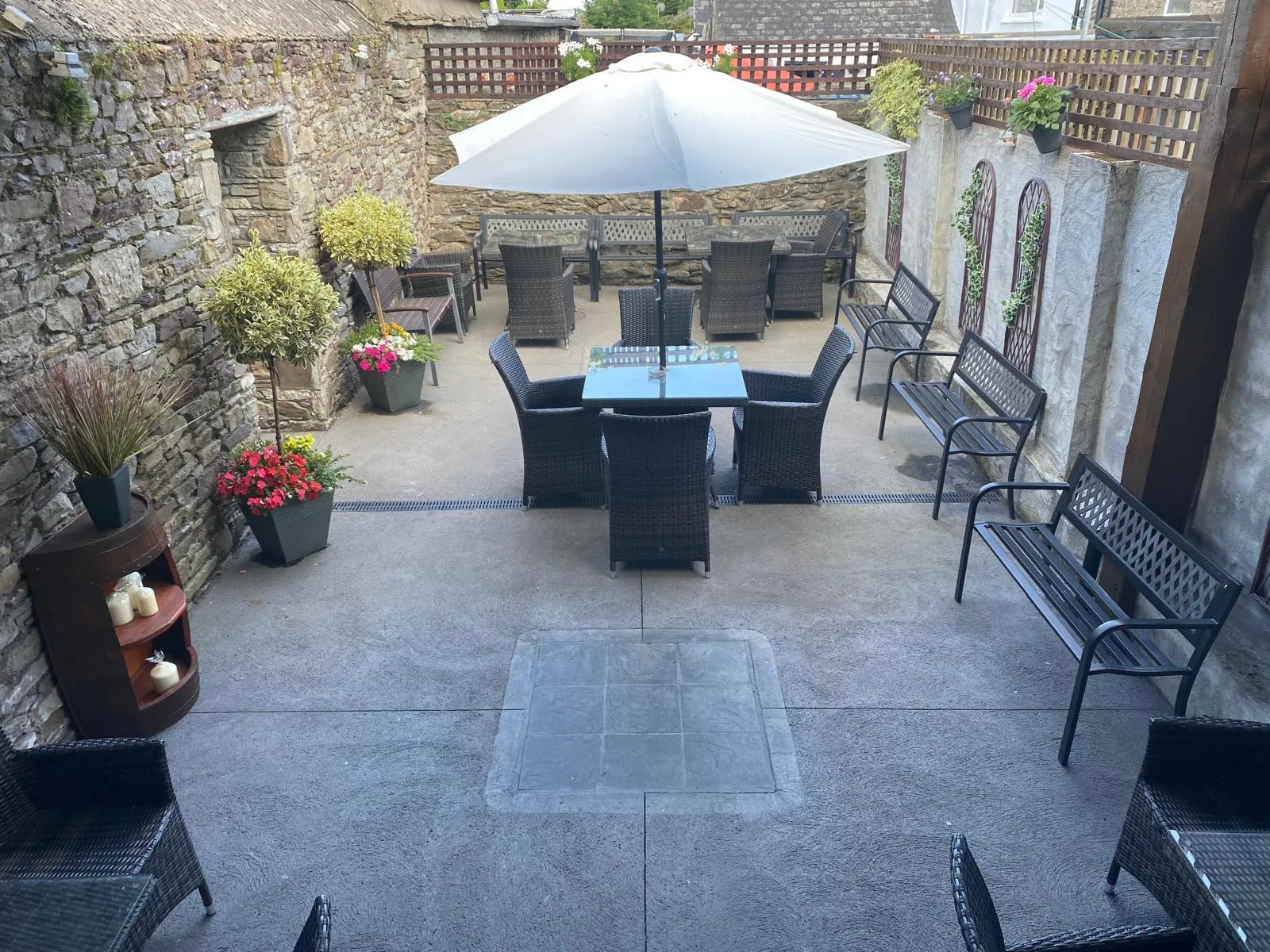 The sheltered beer garden with stone walls, flowers and outdoor seating