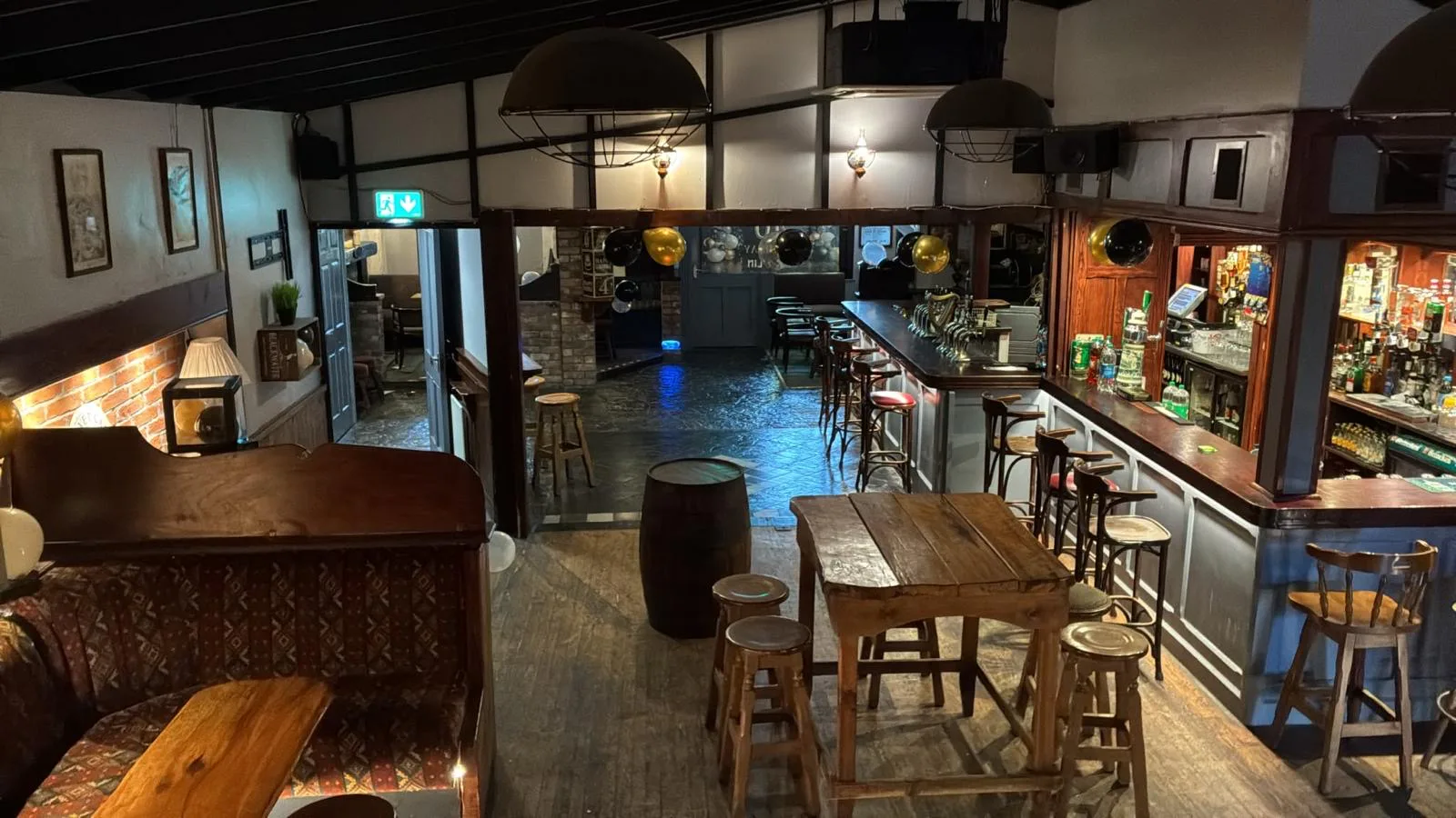 The main bar with timber tables, stools and warm lighting